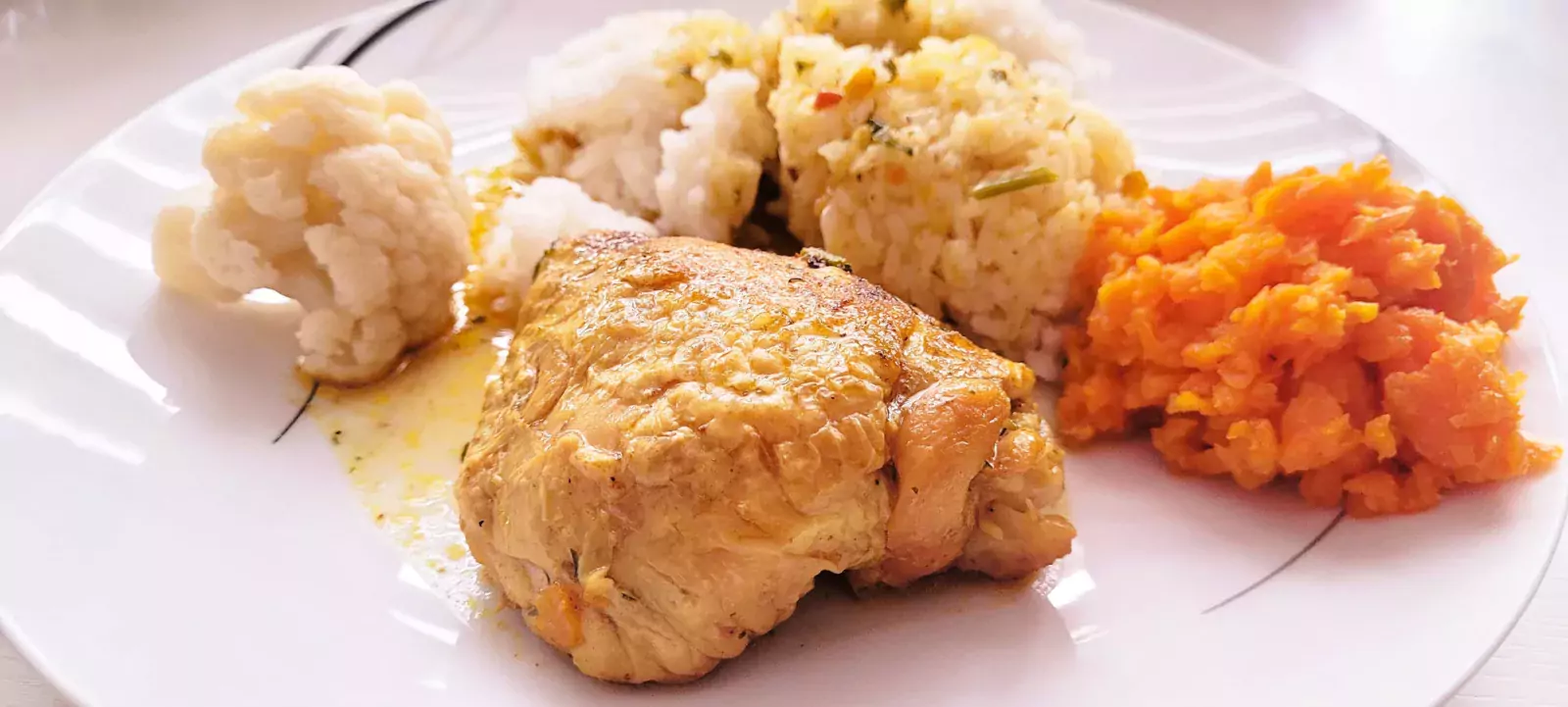 Kurczak w sosie własnym podawany z ryżem, kalafiorem i marchewką